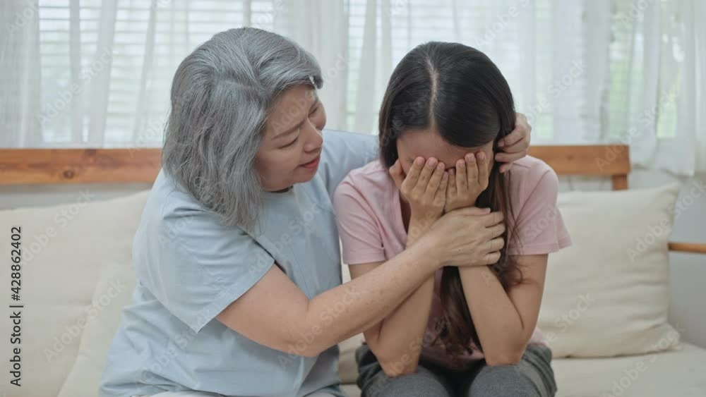 Asian girl daughter crying, mother sitting beside giving consolation. Asian girl daughter crying, mother sitting beside giving consolation.