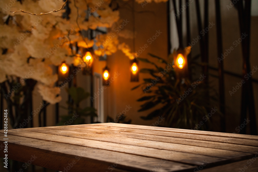 image of wooden table in front of abstract blurred background of restaurant lights image of wooden table in front of abstract blurred background of restaurant lights