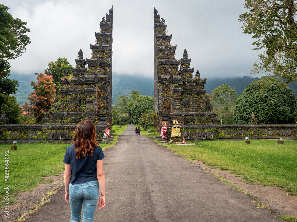 Young female traveler at famous Hindu temple gates in north Bali, Indonesia.