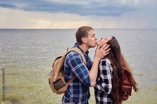Couple in love kissing on nature travel hiking in Hawaii mountains. Young hikers people happy together.