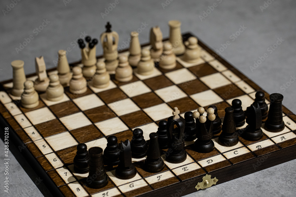 Wooden Chess pieces on board, arranged in incorrect initial position. White king wrong Chessboard squarel. Children's formation error, chess for beginners. first chess lesson to arrange pieces Wooden Chess pieces on board, arranged in incorrect initial position. White king wrong Chessboard squarel. Children's formation error, chess for beginners. first chess lesson to arrange pieces