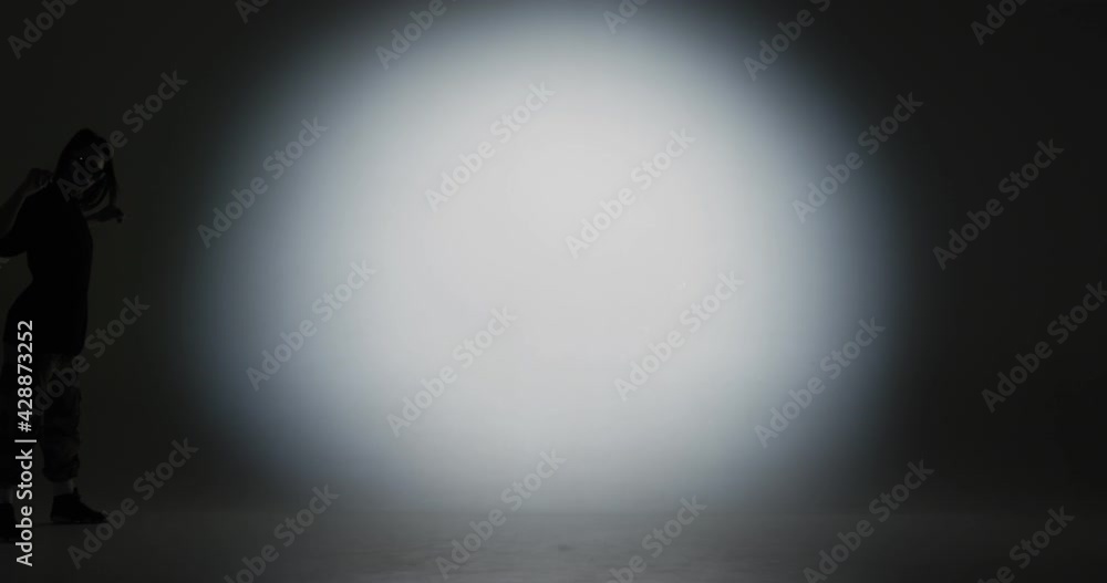 Stylish modern young dancing girl appears in the frame, dances in spotlight and leaves the stage Stylish modern young dancing girl appears in the frame, dances in spotlight and leaves the stage