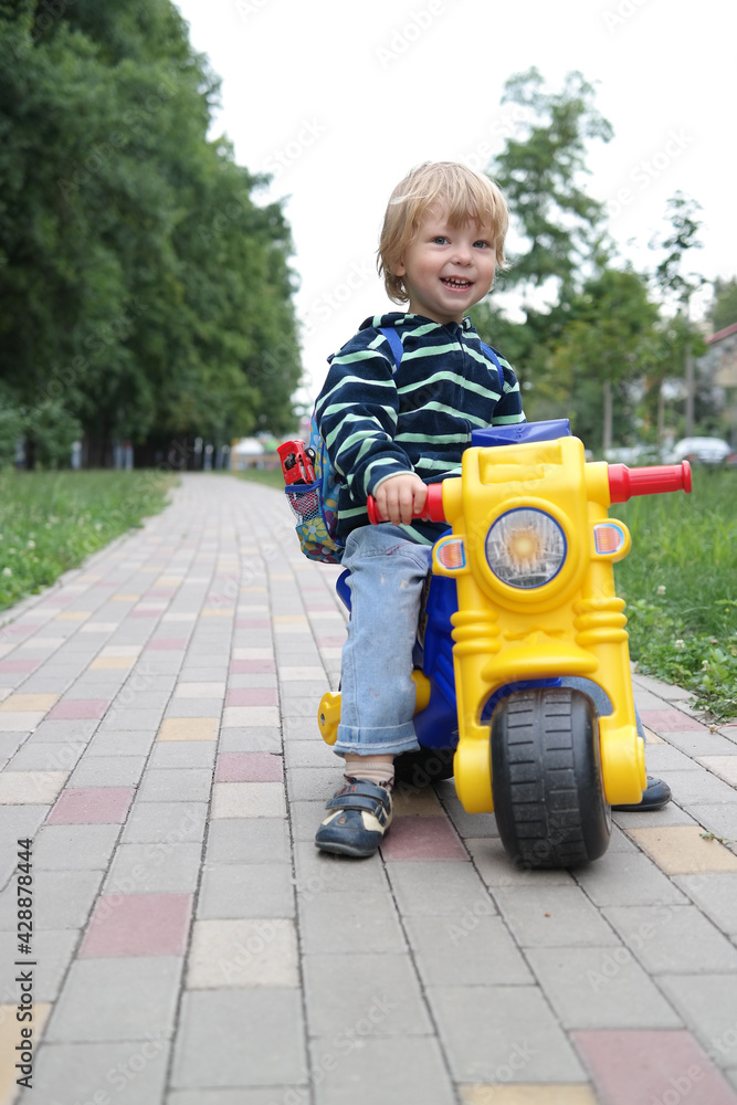 The little boy child is riding on a bicycle tolocar at the park. The little boy child is riding on a bicycle tolocar at the park.
