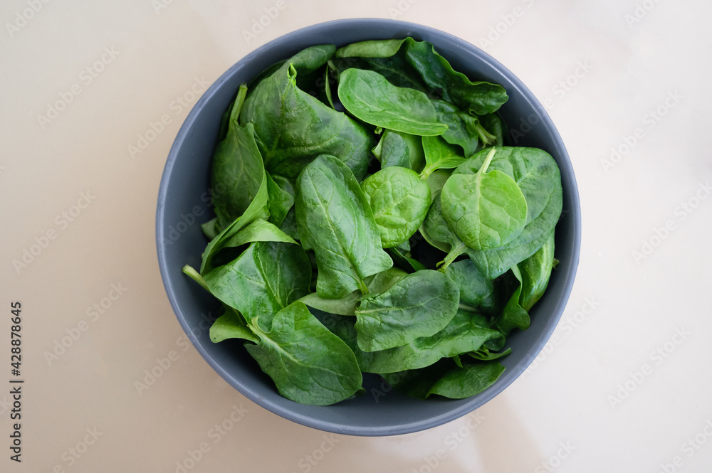 Fresh spinach leaves in bowl on table. Top view. Fresh spinach leaves in bowl on table. Top view.