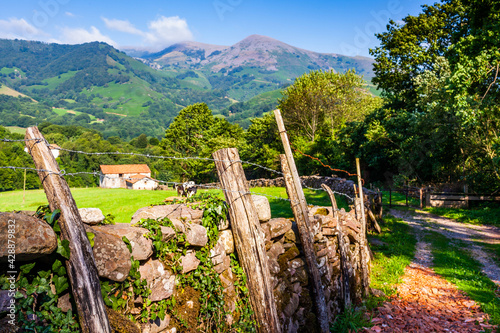 Casa de campo en prado del Valle del Baztan de Navarra tras muro de piedra. Navarra. España