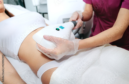 Young attractive woman in white bikini getting Cool sculpting procedure for body slimming. Cryolipolyse and body contouring treatment, anti-cellulite and anti-fat therapy in beauty salon