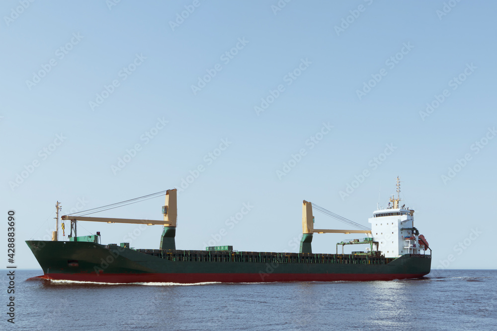 A large cargo ship is sailing at sea. Soft focus