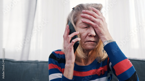 Obraz na plátne Desperate old woman having phone conversation with tears