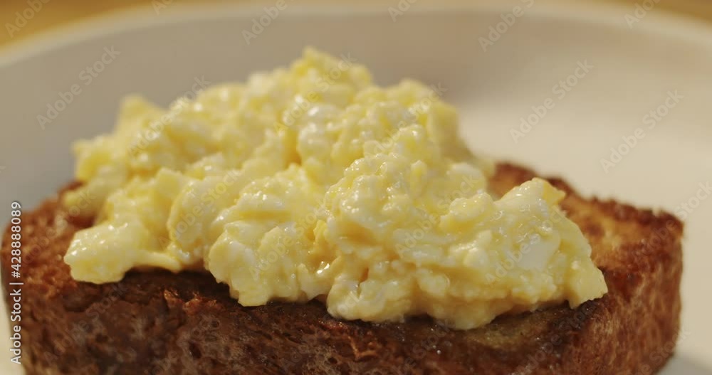 Freshly fried tender and juicy omelet is laid out with a spoon on crispy toast bread Freshly fried tender and juicy omelet is laid out with a spoon on crispy toast bread