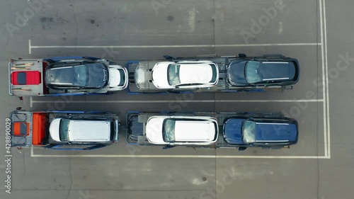 Aerial top down view of a car transporter loaded with cars on a parking lot photo