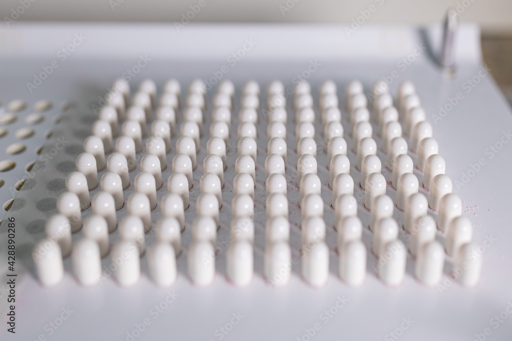 making white capsules. compounding pharmacy. compounding green medication. making white capsules. compounding pharmacy. compounding green medication.