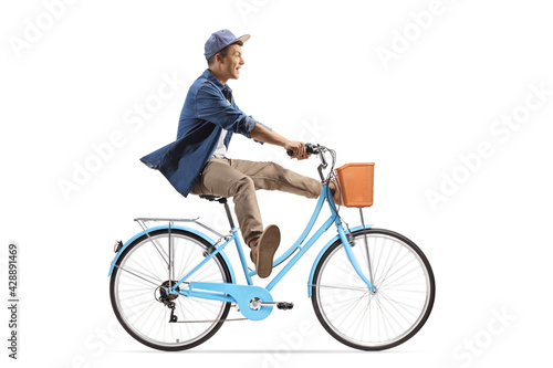 Full length profile shot of a guy riding a bicycle and lifitng legs