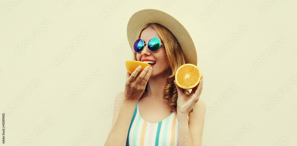 Summer portrait of happy smiling young woman with slices of orange wearing a straw hat, sunglasses on a white background Summer portrait of happy smiling young woman with slices of orange wearing a straw hat, sunglasses on a white background