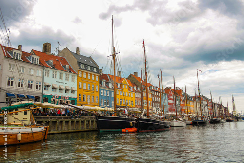 View of the famous Nyhavn, Copenhagen, Denmark, with the canal and moored sailboats