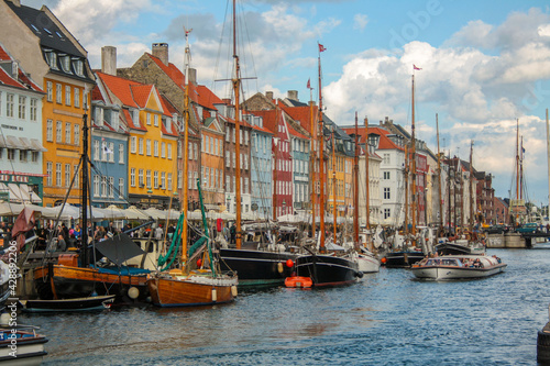 View of the famous Nyhavn, Copenhagen, Denmark, with the canal and moored sailboats