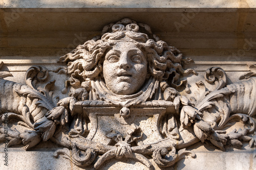 Visage de femme sculpté en pierre, probablement une allégorie de la fortune, ornement de façade d'un immeuble ancien de Paris, France