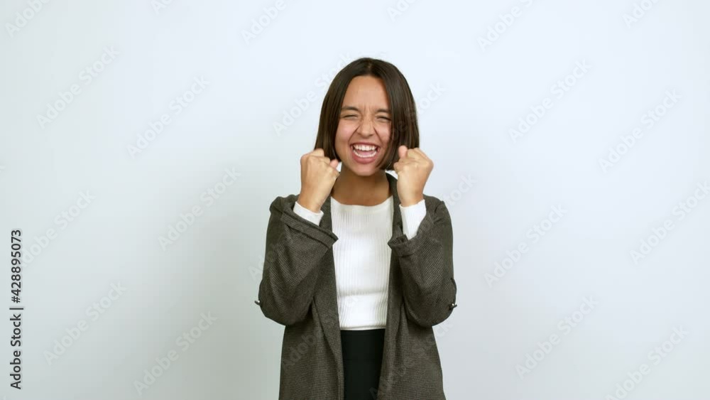 Young latin woman celebrating a victory and surprised to be successful over isolated background Young latin woman celebrating a victory and surprised to be successful over isolated background