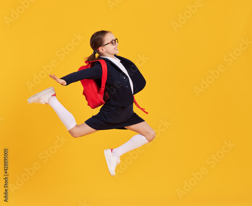 Excited schoolgirl jumping high in studio © JenkoAtaman