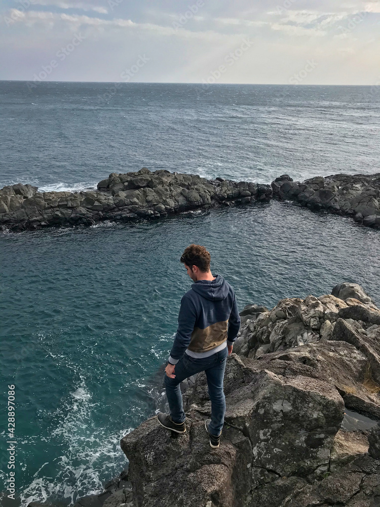 Young man posing and jumping on the sea side