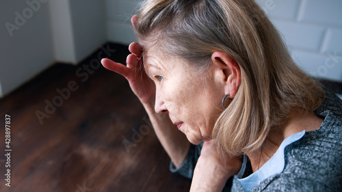 Fotografia desperate lonely elderly woman having a headache