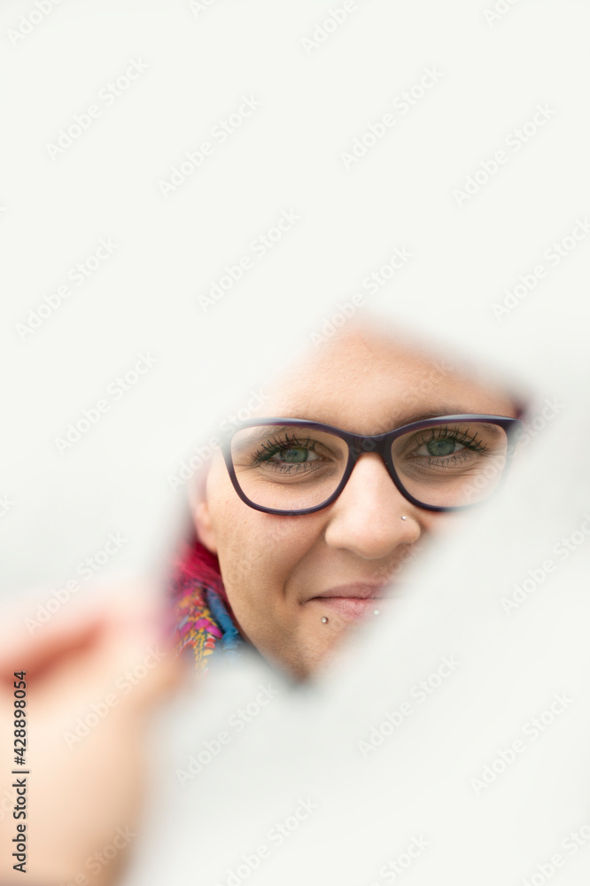 Fototapeta premium Frau mit roten Haaren spiegelt sich in einer Spiegelscherbe, Nahaufnahme