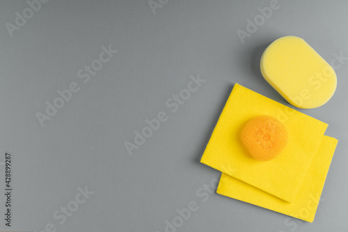 Top view of yellow, washing sponges and rags isolated on gray background.