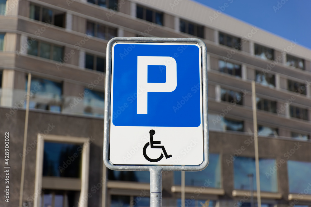 blue traffic sign with wheelchair symbol, handicapped parking, only authorized persons with valid identification are allowed to park here, by day, without persons blue traffic sign with wheelchair symbol, handicapped parking, only authorized persons with valid identification are allowed to park here, by day, without persons