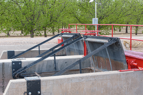 Irrigation of pecan groves. Water from a network of ditches, or acequias is diverted through pipes into  the fields of trees. Floodgates like these control the flow through the large acequias. 
 photo