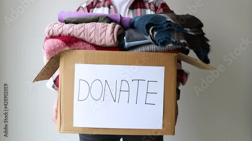 Man holding a clothes donate box. Donation concept.	