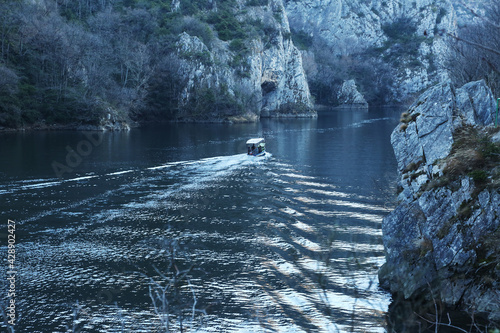 Boat goes by the river in Matka Canyon in Skopje, Macedonia. Matka is one of the most popular outdoor destinations in Macedonia.