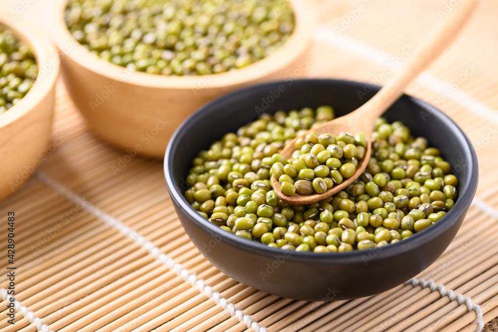 Mung bean seeds in a wooden spoon and bowl, Food ingredients in Asian cuisine and produce mung bean sprout Mung bean seeds in a wooden spoon and bowl, Food ingredients in Asian cuisine and produce mung bean sprout