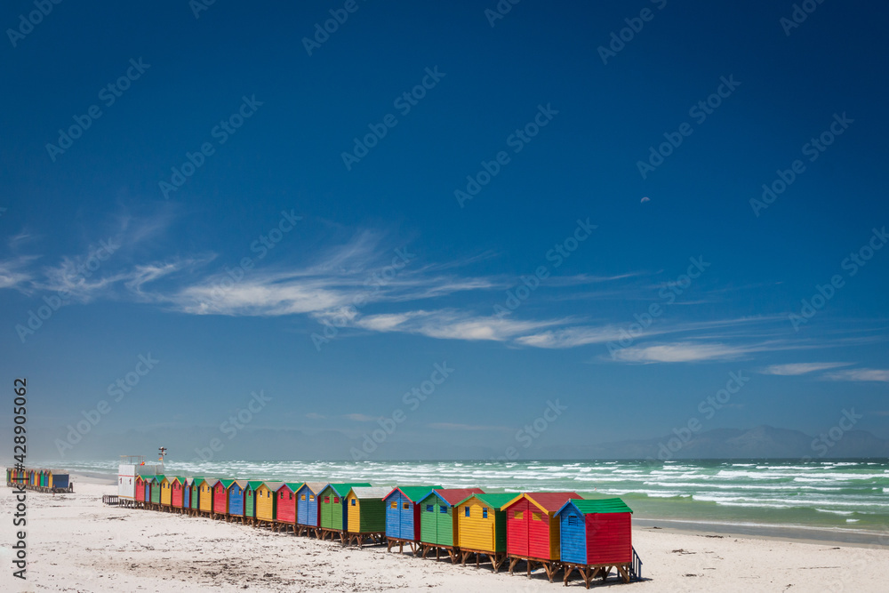 Fototapeta premium Famous colorful beach houses in Muizenberg near Cape Town, South Africa with Hottentots Holland mountains in the background.