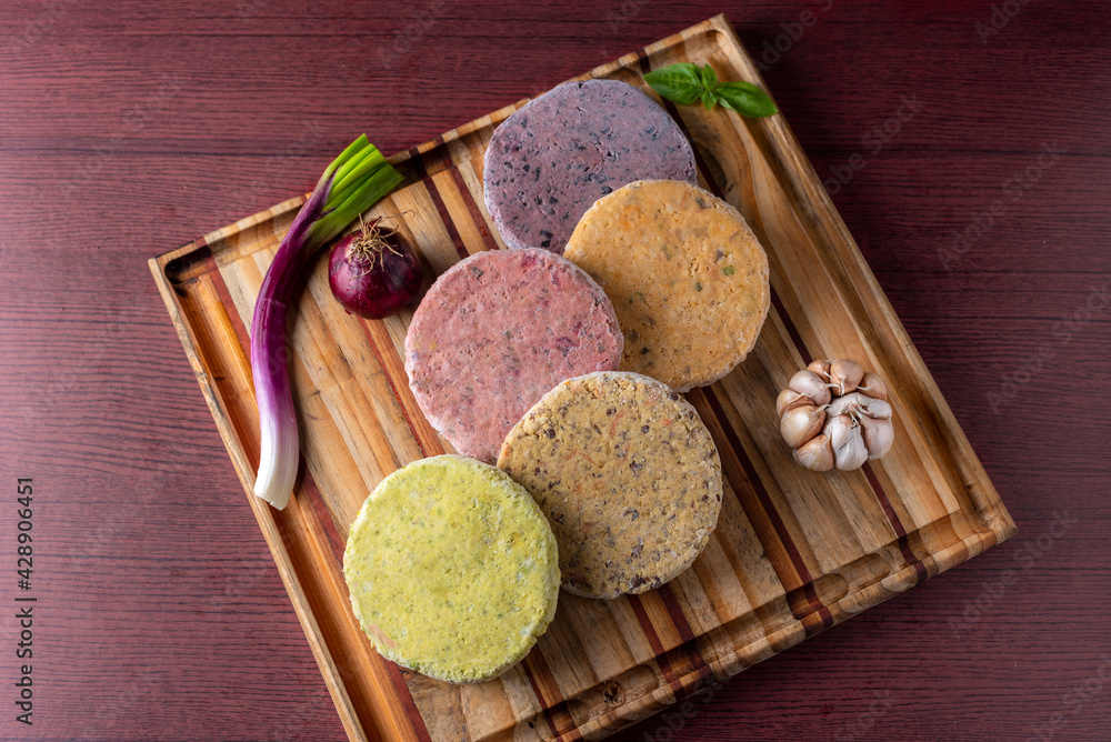 Vegan and vegetarian assorted legume and vegetable burgers of different colors on wooden board for a healthy and healthy life Vegan and vegetarian assorted legume and vegetable burgers of different colors on wooden board for a healthy and healthy life