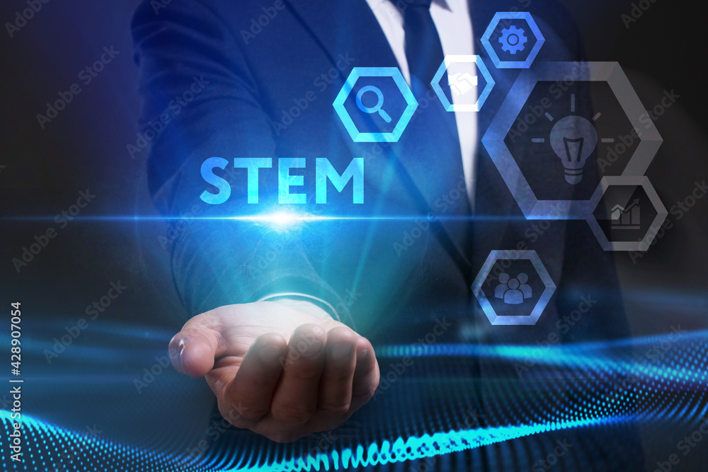Business, Technology, Internet and network concept. Young businessman working on a virtual screen of the future and sees the inscription: STEM Business, Technology, Internet and network concept. Young businessman working on a virtual screen of the future and sees the inscription: STEM
