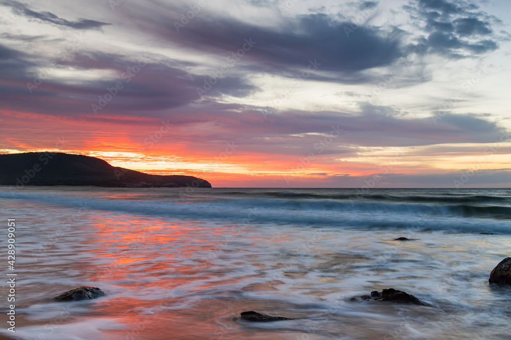 Obraz premium Sunrise at the seaside with pastel coloured clouds