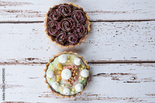 Closeup of two pies with buttery dough. Topping with pistachio cream and dark chocolate. photo