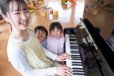 ピアノを弾く保育士と歌う園児