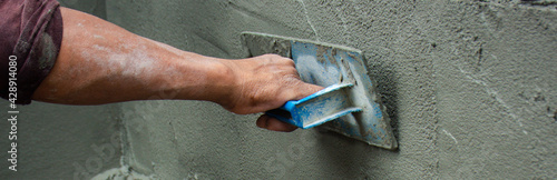 Wallpaper Mural The hands of the construction workers are plastering the walls of the building. Torontodigital.ca