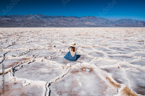 Salt Flats in Death Valley National Park. Silhouette of woman enjoying view. Badwater Basin hiking trail, trail adventure through upheaved salt plates below sea level. photo