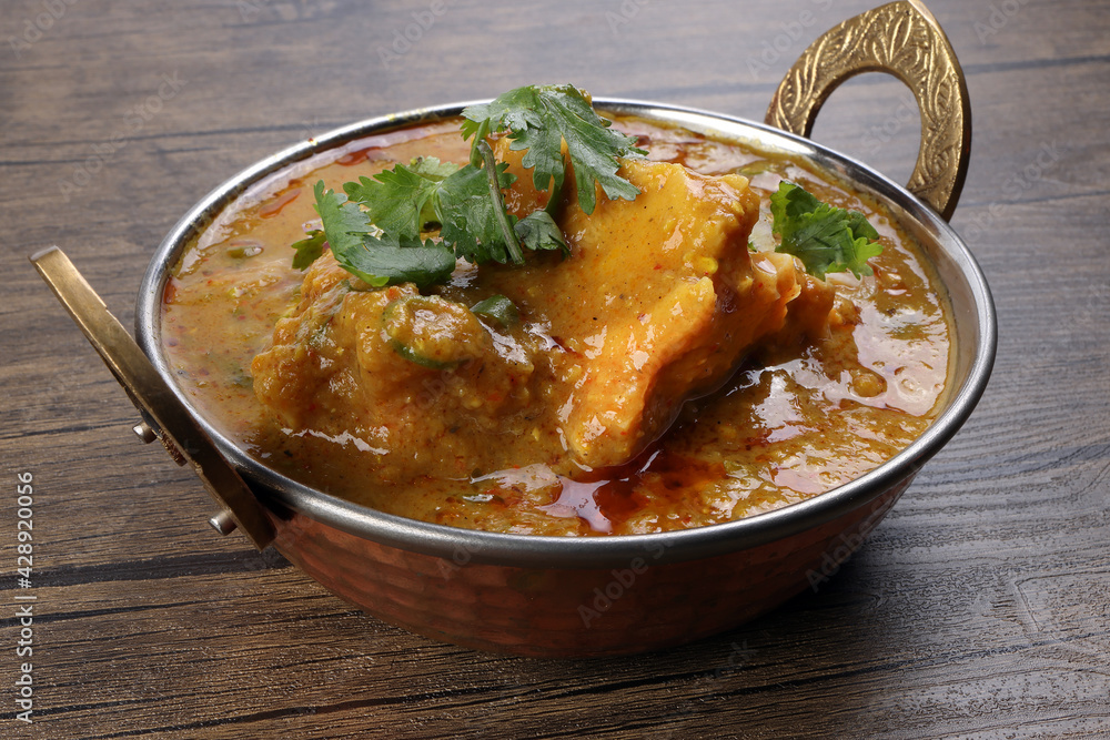 Haleem stew wheat barley lentils mutton goat chicken beef meat bone spice served in a copper brass pot over rustic wood background Haleem stew wheat barley lentils mutton goat chicken beef meat bone spice served in a copper brass pot over rustic wood background