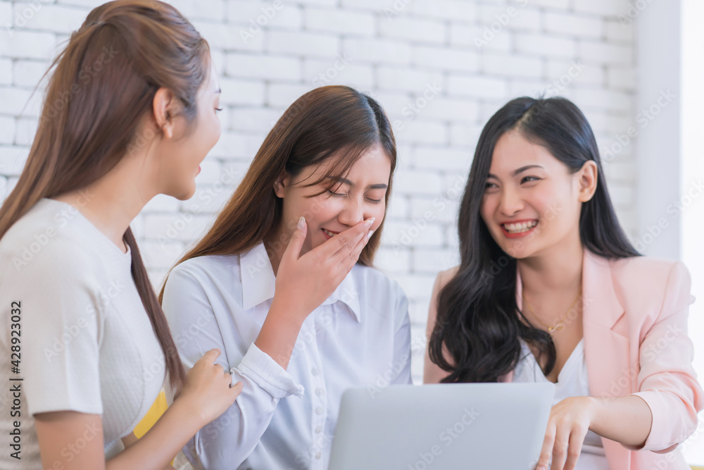 Beautiful young business women are looking on website by laptop at living room. Happy friendship relationship concept Beautiful young business women are looking on website by laptop at living room. Happy friendship relationship concept