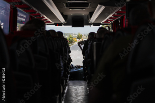 A full bus of tourist passengers traveling on the motorway at a resort on the sea, the view between the seats