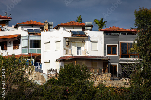 Two-storey residential area with small stone white houses with solar panels, air conditioning and sun shutters in a tropical hot country photo