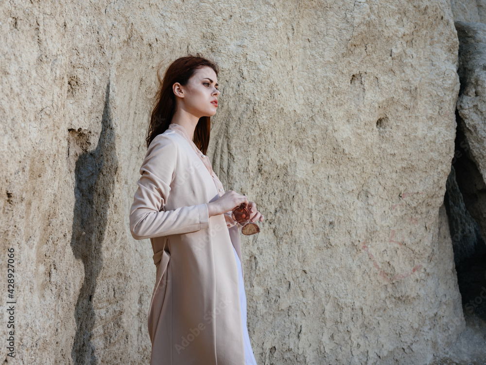 A woman in trousers and a sweater in nature and near large rocks A woman in trousers and a sweater in nature and near large rocks