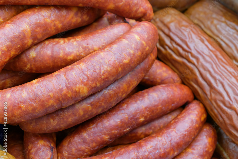 Smoked sausages for the backdrop. Finished meat in a shell with splashes of fat. Butcher shop concept. Smoked sausages for the backdrop. Finished meat in a shell with splashes of fat. Butcher shop concept.
