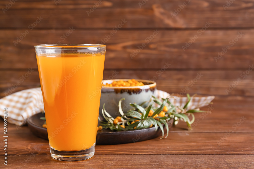 Glass of healthy sea buckthorn juice on table Glass of healthy sea buckthorn juice on table