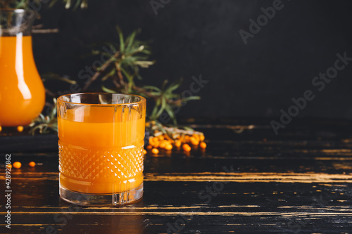 Glass of healthy sea buckthorn juice on table