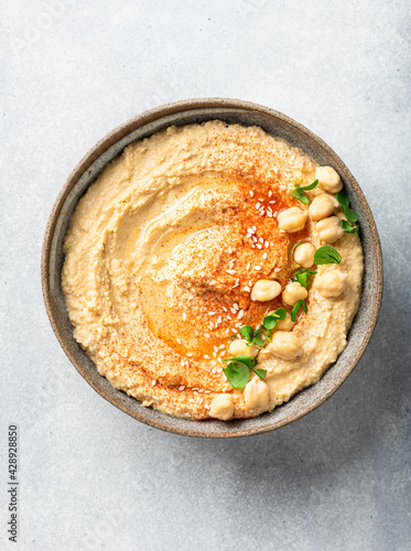 Schilderij op canvas hummus in a ceramic bowl on a light background, top view