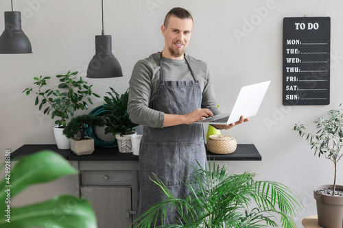 Young gardener with laptop ...