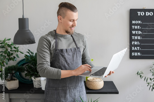 Young gardener with laptop ...
